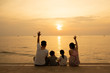 silhouette of family sitting on the beach at sunset