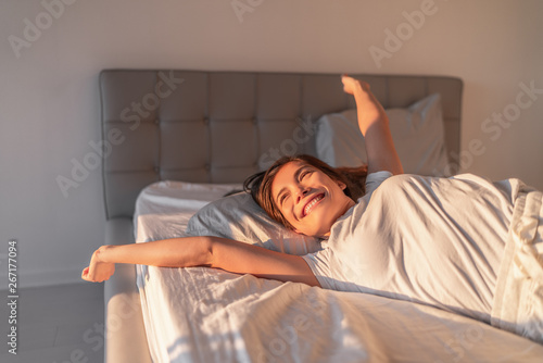 Fotografía Happy girl waking up in the morning sunshine looking at sunrise sun in window excited to enjoy the day