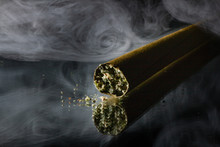 Stylized Cannabis Blunt Photograph with weed crumbs and smoke in the background