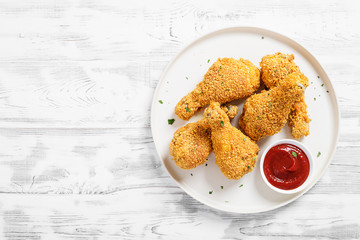 Wall Mural - Crispy  fried chicken drumsticks  in a wooden table.