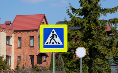 road sign pedestrian crossing sunny day among green leaves