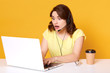 © sementsova321 - Short haired shocked attractive operator posing with wide opened mouth and eyes, looking at laptop screen, typing some information, having headset, working hard at call center. Work concept.