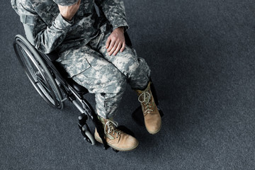 Overhead view of depressed disabled man in military uniform sitting in wheelchair