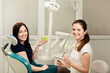 © Olha - Beautiful woman patient having dental treatment at dentist's office. Smiling woman holds an apple