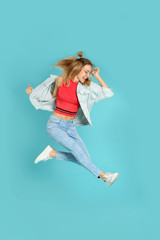 Sticker - Full length portrait of emotional woman jumping on color background