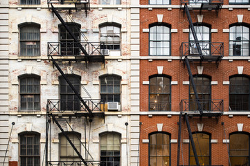 Close-up view of New York City style apartment buildings with emergency stairs along Mott Street in Chinatown neighborhood of Manhattan, New York, United States.