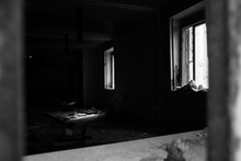 Destroyed Room In Abandoned Building. Sun Rays Light Up Messy Apocalyptique Interior. Decay Concept. Black White Photo.