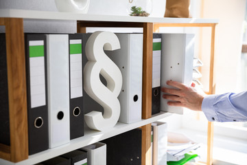 Businessperson Taking Folder From Shelf