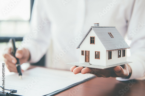 Fotomural House model with real estate agent and customer discussing for contract to buy house, insurance or loan real estate background