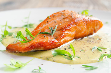 Wall Mural - fried fish fillet with fresh herbs and spices in lemon-mustard sauce 