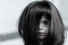 The Face Of A Creepy Girl Doll With Long Hair. Doll Face Closed By Hairs