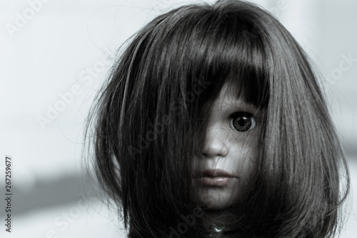 creepy girl with black hair and doll