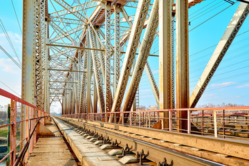 Reliable railway bridge, against the backdrop of beautiful nature and blue sky. Looking through the bridge. Backgound