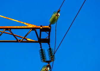 Detail of rusty power tower against deep blue sky