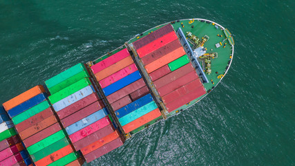 Container ship loading and unloading in deep sea port, Aerial top view of logistic import export transportation business by container ship in open sea.