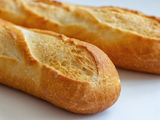 Crispy Golden crust of French baguettes on a light background. Two mouth-watering French baguette