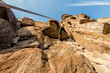 Climber Extreme climbs a rock on a rope with the top insurance, against the blue sky, bottom view