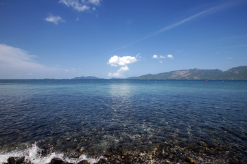 Wall Mural - Idyllic crystal seawater in front of luxury hotel, attractive clear sea, nature coastline backgrounds during holidays, wave from clear blue green sea and fine sand