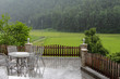 © leomalsam - Terrace with table and chairs in rainy weather