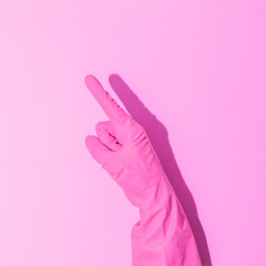 Wall Mural - Fashion creative concept with hand in pink rubber glove, showing gesture. Symbol of point. Aesthetic abstract minimalism.