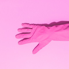 Wall Mural - Fashion creative concept with hand in pink rubber glove, showing gesture.  Aesthetic abstract minimalism. Flat lay