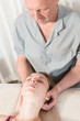 © yanik88 - Male manual visceral therapist masseur treats a young female patient. Head and ear massage