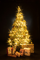 Wall Mural - Gifts and golden Christmas tree bokeh in a black background