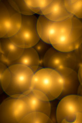 Wall Mural - Decorative golden color bubbles bokeh on a black background. Lights for christmas