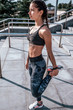© byswat - Woman athlete girl fitness workout, summer city day morning. Active lifestyle concept warming up jogging. Sportswear leggings. Motivation and strength. Stretching muscles legs gymnastics, plasticity.