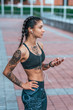 © byswat - Woman athlete girl fitness workout summer city motivation power tattoo. Active lifestyle, mobile phone, headphones online application Internet listening music. Sportswear leggings top. Rest exercise.