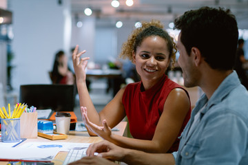 Working woman and man sharing idea about their work in co working place