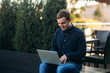 © Aleksandr - Man typing on his laptop. Backgroung of green tree