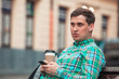 © phpetrunina14 - portrait of young handsome man sitting on bench drinking coffee browsing internet via phone