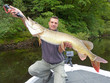 © sablin - Fisherman holding a big pike. Catch of fish, freshwater fishing, lure fishing