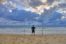 Surf Fisherman Waiting For Fish On A Beach Of Atlantic Ocean. Adventure Fishing, Wild Fishing