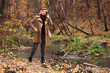 © Wrangler - Happy young fashion woman with handbag walking in autumn park