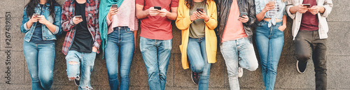 Zdjęcie: Group of friends using their smart mobile smartphones outdoor - Millennial young people addicted to new technology trends apps - Concept of people, tech, social media, generation z and youth lifestyle Group of friends using their smart mobile smartphones outdoor - Millennial young people addicted to new technology trends apps - Concept of people, tech, social media, generation z and youth lifestyle