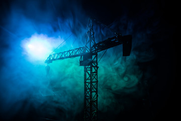 Abstract Industrial background with construction crane silhouette over amazing sunset sky. Tower crane against the evening sky. Industrial skyline