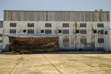 Abandoned wooden ship hull on the side of a shipyard