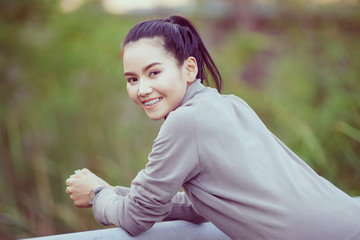 Health, sport and workout concept - Young Asian woman warm up body before jogging and workout daily. Female runner does stretching body to warm up before exercise.