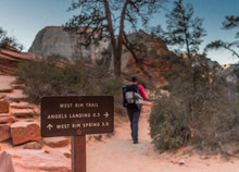Hiker Passes West Rim Trail Sign