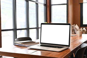 Laptop computer on working table with a wood desk.