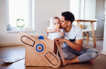 Wall Mural - Father and small toddler son indoors at home, playing.