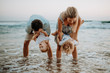 © Halfpoint - A young family with two toddler children having fun on beach on summer holiday.