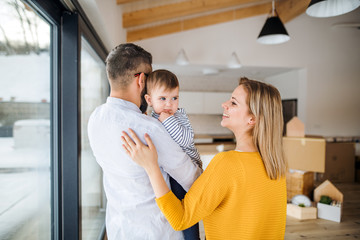 Wall Mural - A young family with a toddler girl moving in new home.