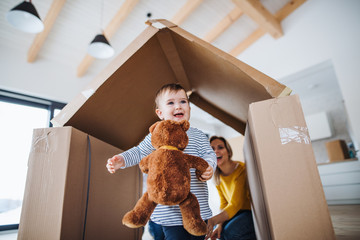 A portrait of young family with a toddler girl, moving in new home concept.