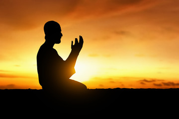 Silhouette of muslim man praying