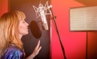 Wall Mural - Pretty female singer recording voice in sound studio