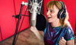 © leszekglasner - Female with microphone recording a voice for dubbing in music studio