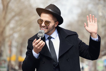 Canvas Print - Handsome man with microphone outdoors